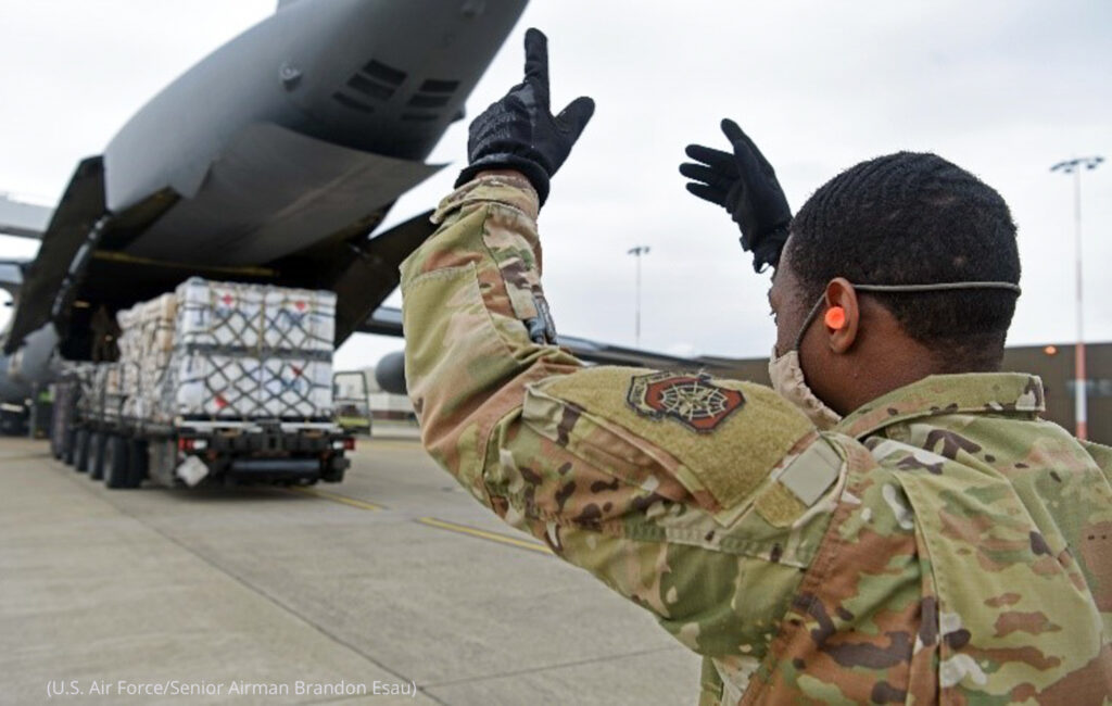 Staff Sgt. Kalem Postell, 727th Air Mobility Squadron security manager, marshals a K-loader during the loading of pallets and equipment onto a C-5 Super Galaxy assigned to the 9th Airlift Squadron, Dover Air Force Base, Delaware, during a medical cargo mission at RAF Mildenhall, England, April 18, 2020. The 9th AS and the 727th AMS, based at RAF Mildenhall, took part in a mission which involved delivering COVID-19 test kits and other equipment to Accra, Ghana, to be distributed throughout the U.S. African Command area of responsibility. (U.S. Air Force photo by Senior Airman Brandon Esau) https://www.africom.mil/article/32763/dod-supports-african-partner-nations-in-multiple-ways